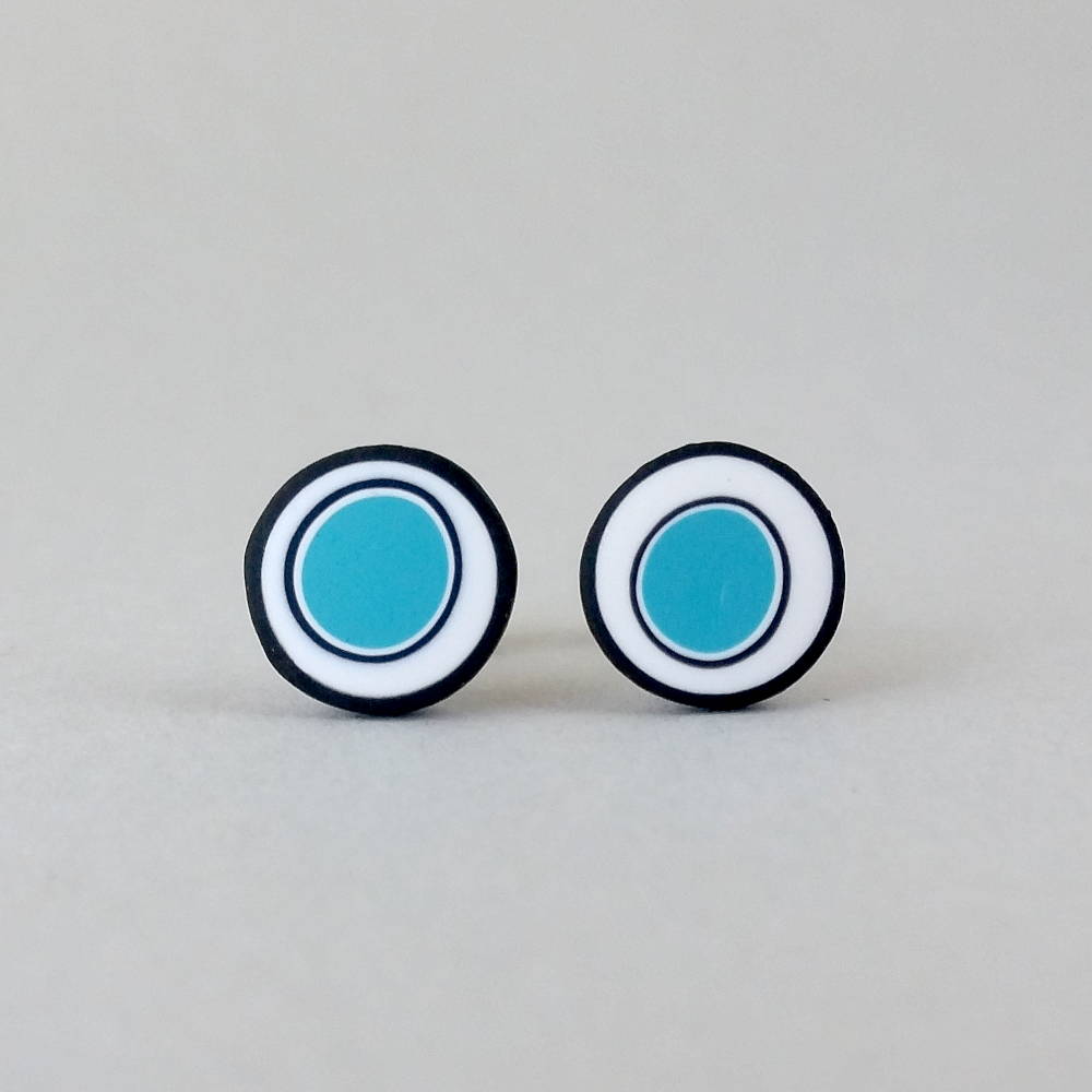 Handmade stud earrings with organic circles of turquoise on a white background with a black border.